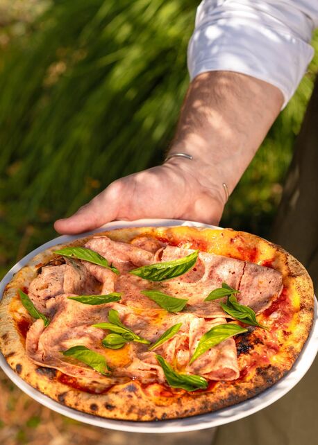 A finished pizza with Journeyman cured meats and basil at Appellation Healdsburg