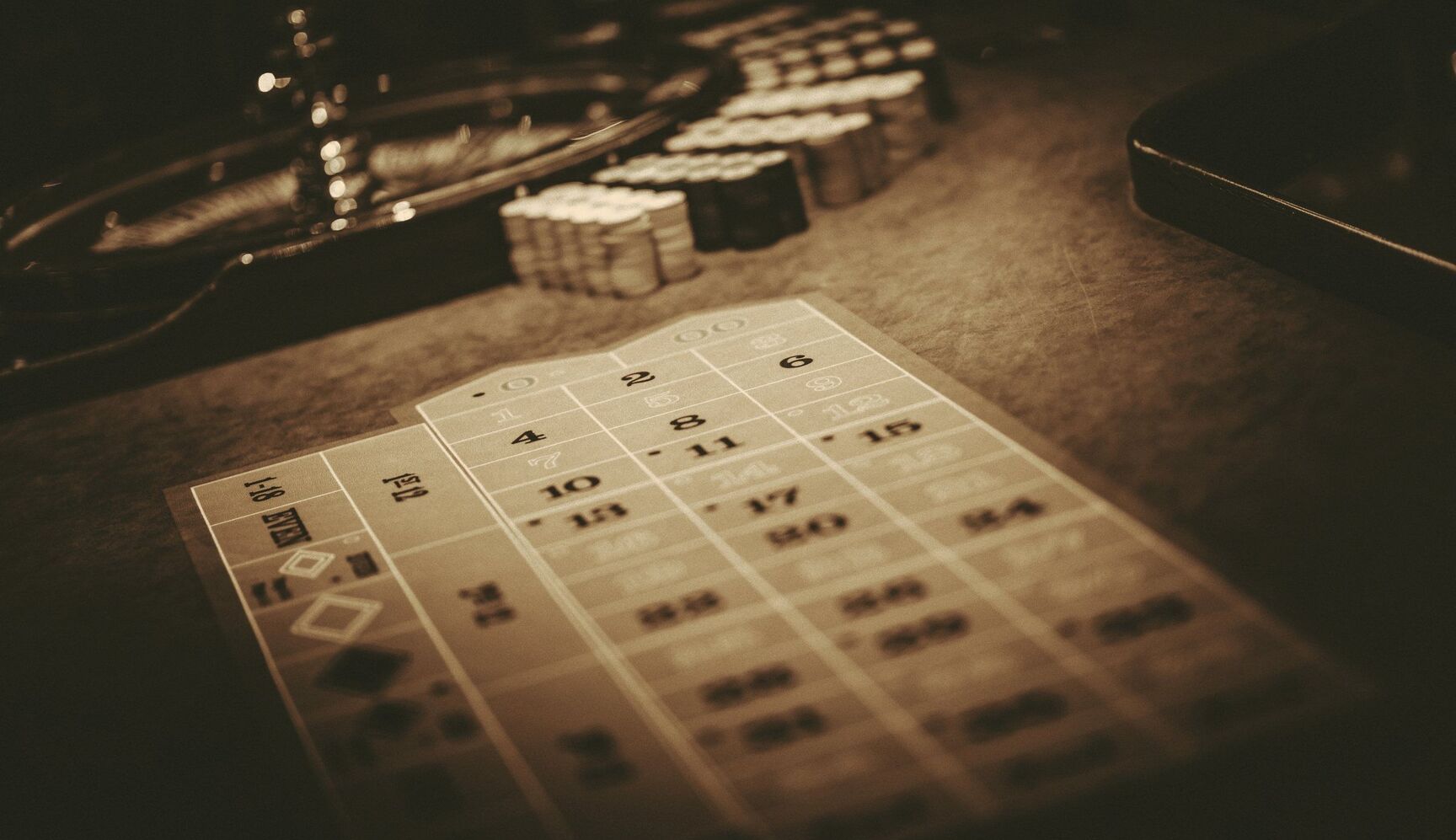 Roulette table and casino chips in warm low light