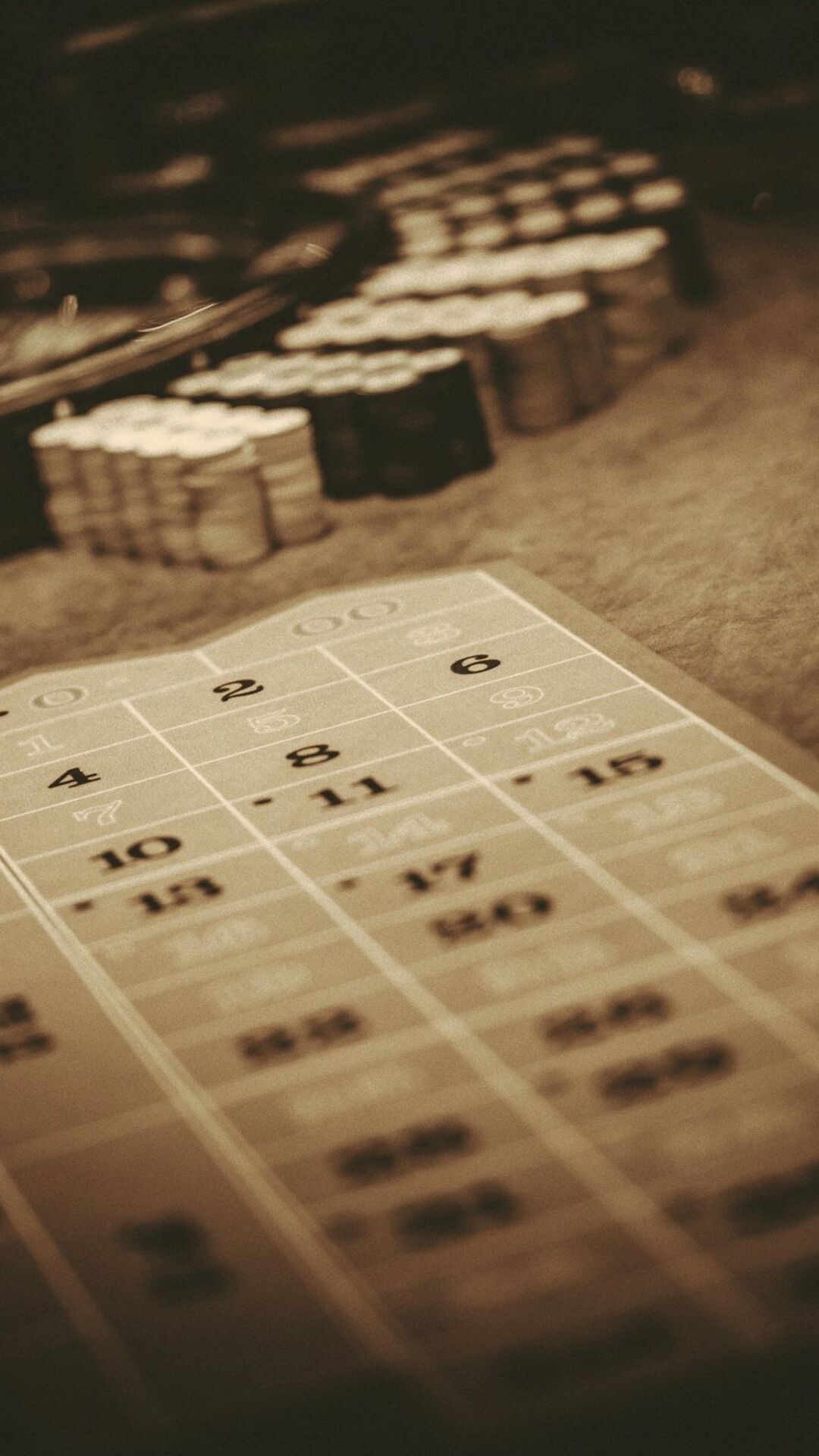 Roulette table and casino chips in warm low light