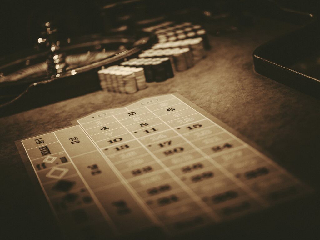 Roulette table and casino chips in warm low light